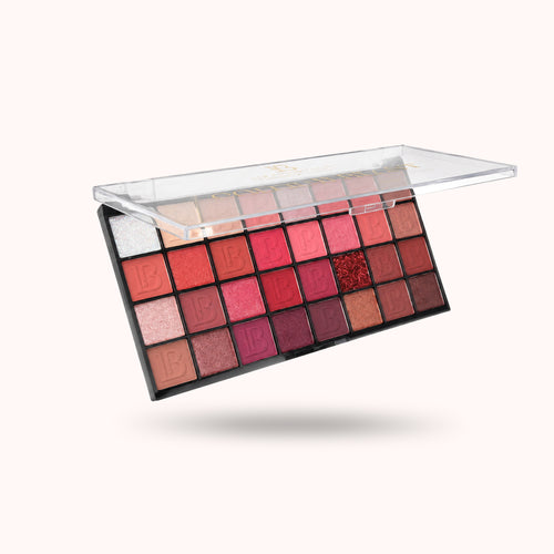 A 32-shade eyeshadow palette with a clear plastic lid, shown open and floating against a light cream background.