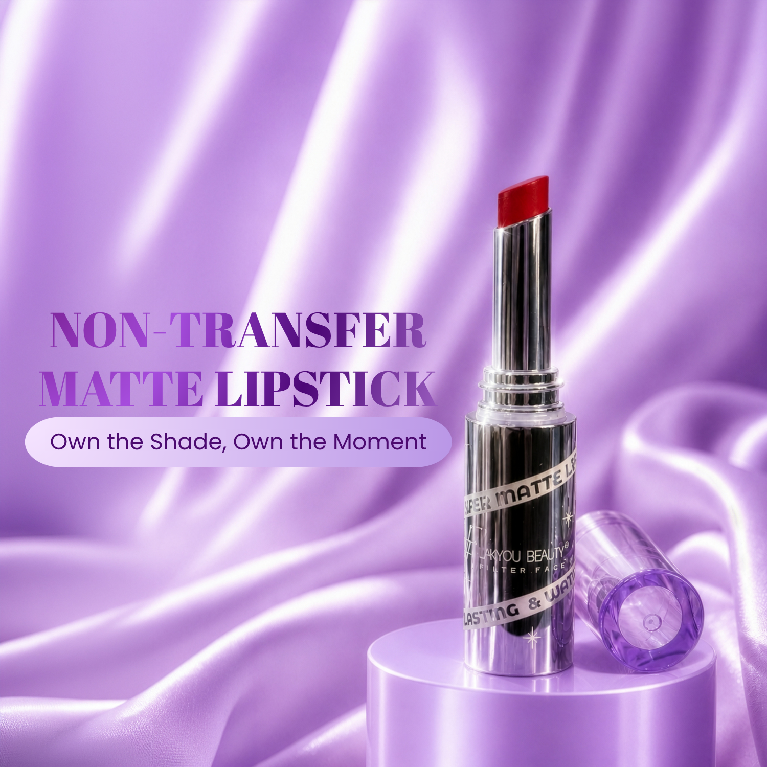 A matte lipstick tube with a silver body and a red lipstick bullet stands on a lavender pedestal against a purple satin fabric background. The text reads 'NON-TRANSFER MATTE LIPSTICK' and 'Own the Shade, Own the Moment.